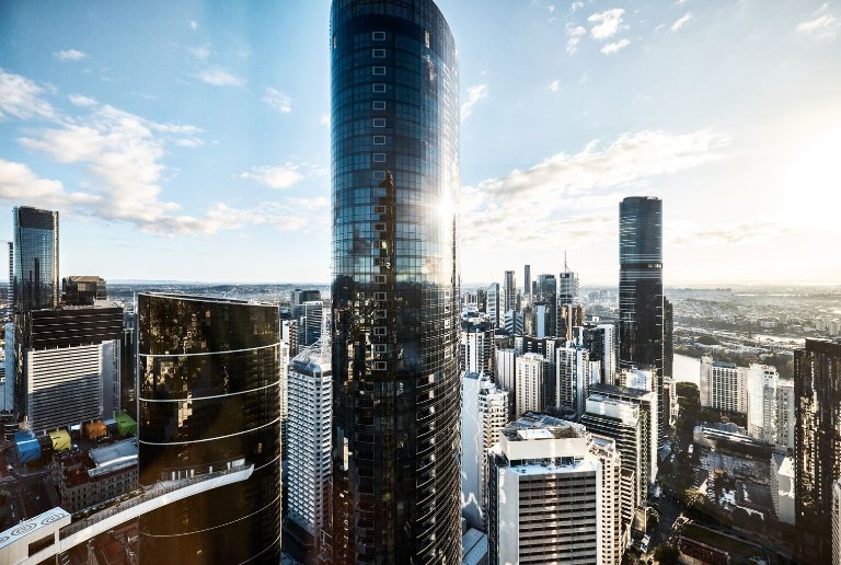 Brisbane CBD skyline featuring modern glass office towers and high-rise buildings under a bright daytime sky.